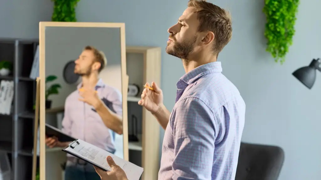 Persona practicando respuestas conductuales frente al espejo con notas adhesivas